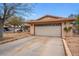 Home exterior featuring a long driveway leading to a two-car garage with decorative trim at 6858 Groveview Ln, Las Vegas, NV 89103