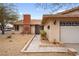 A single-story home with a brick chimney, low-maintenance yard, and an attached two-car garage at 6858 Groveview Ln, Las Vegas, NV 89103