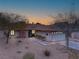 The home features warm exterior lighting, a brick chimney, and drought-tolerant landscaping at 6858 Groveview Ln, Las Vegas, NV 89103