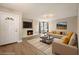 Staged living room featuring a fireplace, a comfortable sofa, and hardwood floors at 6858 Groveview Ln, Las Vegas, NV 89103