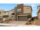 Modern home with neutral colors, two-car garage, desert landscaping, and paver driveway at 6901 Whisper Canyon Pl, North Las Vegas, NV 89084