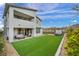 Spacious backyard with artificial grass, a hot tub, and a covered patio area at 705 Carlon Hills Ave, Las Vegas, NV 89138