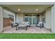 Charming covered patio with stylish furniture, sliding glass doors, and views of the green yard at 705 Carlon Hills Ave, Las Vegas, NV 89138