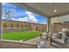 Relaxing covered patio with brick pavers, comfortable seating, and views of the lush backyard at 705 Carlon Hills Ave, Las Vegas, NV 89138