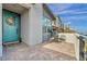 Stylish front porch featuring brick pavers, a turquoise door, and a cozy seating area at 705 Carlon Hills Ave, Las Vegas, NV 89138