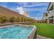 Relaxing hot tub in a private backyard setting, surrounded by lush greenery and a tall brick wall at 705 Carlon Hills Ave, Las Vegas, NV 89138