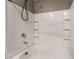 Close-up of a white bathtub with a white tile surround and shower accessories at 7219 Quiet Spring St, North Las Vegas, NV 89084