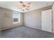 Cozy bedroom featuring a ceiling fan, large window, and soft gray carpet for a comfortable ambiance at 7219 Quiet Spring St, North Las Vegas, NV 89084