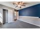 Inviting bedroom with a ceiling fan, blue accent wall, and cozy gray carpet, ready for personalization at 7219 Quiet Spring St, North Las Vegas, NV 89084