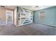 Bright, open bedroom featuring a unique accent wall, neutral carpet, and a ceiling fan at 7219 Quiet Spring St, North Las Vegas, NV 89084