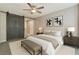 A staged bedroom showcasing a barn door, ceiling fan, and neutral color palette at 7219 Quiet Spring St, North Las Vegas, NV 89084