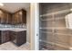 Walk-in pantry with wire shelving, adjacent to the kitchen with modern appliances and granite counters at 7219 Quiet Spring St, North Las Vegas, NV 89084