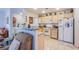 A bright kitchen featuring white appliances, light wood cabinets and a breakfast bar open to the living area at 7400 W Flamingo Rd # 1087, Las Vegas, NV 89147