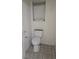Bathroom featuring a standard toilet, window and tile flooring at 7904 Limbwood Ct, Las Vegas, NV 89131