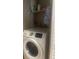 Enclosed laundry area featuring a front-load Samsung washing machine and storage shelves at 8600 W Charleston Blvd # 1075, Las Vegas, NV 89117