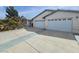 Spacious house featuring a multi-car garage, desert landscaping, and a long driveway at 901 E Jaybird St, Pahrump, NV 89048
