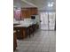 Bright kitchen featuring tiled floors, wood cabinets, tiled countertops, and bar seating at 901 E Jaybird St, Pahrump, NV 89048