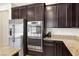 Updated kitchen features stainless steel appliances, granite countertops, and dark wood cabinetry at 9268 Wildfire Gorge St, Las Vegas, NV 89139