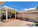 Backyard patio with hot tub, brick wall, string lights, and mature landscaping at 9359 Brownstone Ledge Ave, Las Vegas, NV 89149