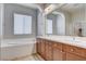 Bright bathroom featuring a double sink vanity, soaking tub, and tile flooring at 9359 Brownstone Ledge Ave, Las Vegas, NV 89149