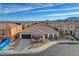 A single-story house showcases a tile roof, attached two-car garage, and landscaped front yard, complemented by an arched entrance at 9359 Brownstone Ledge Ave, Las Vegas, NV 89149
