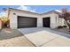 Spacious three-car garage featuring a paved driveway and low-maintenance desert landscaping around the perimeter of the home at 9359 Brownstone Ledge Ave, Las Vegas, NV 89149
