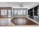 Open living space with modern ceiling fan, built-in shelves, and ample natural light through multiple windows and a glass door at 9359 Brownstone Ledge Ave, Las Vegas, NV 89149