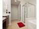 Bright bathroom with a shower, bathtub, and double sinks with vanity cabinet at 10091 Sand Key St, Las Vegas, NV 89178