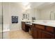 Bathroom boasts double sinks with wooden cabinets and a shower area with glass doors at 10091 Sand Key St, Las Vegas, NV 89178