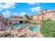 Community pool with jacuzzi, sun loungers, and shaded area with chairs and tables at 10091 Sand Key St, Las Vegas, NV 89178
