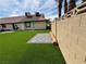 A serene backyard with artificial grass and stone pavers that offers a relaxing and low-maintenance retreat at 1104 Oak Tree Ln, Las Vegas, NV 89108