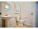 A compact half-bath featuring a pedestal sink, toilet, and a small storage cabinet at 1241 Gingerbread Man Ave, Las Vegas, NV 89183