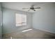 This is a carpeted bedroom with a ceiling fan and a window that lets in natural light at 1241 Gingerbread Man Ave, Las Vegas, NV 89183