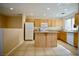 Well-lit kitchen with wood cabinets, tile floors, granite countertops, and a kitchen island at 1241 Gingerbread Man Ave, Las Vegas, NV 89183
