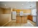 Well-lit kitchen with wood cabinets, tile floors, granite countertops, and a kitchen island at 1241 Gingerbread Man Ave, Las Vegas, NV 89183