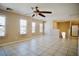 Spacious and bright living room with tile flooring, large windows, and a ceiling fan at 1241 Gingerbread Man Ave, Las Vegas, NV 89183