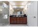 Bright bathroom featuring a double sink vanity, a large mirror, and a glass shower enclosure at 135 E Harmon Ave # 2104, Las Vegas, NV 89109