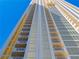 High-rise building featuring multiple floors, windows, and balconies against a bright blue sky at 135 E Harmon Ave # 2104, Las Vegas, NV 89109