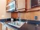 Compact kitchenette featuring granite countertops, stainless steel sink, and modern appliances at 135 E Harmon Ave # 2104, Las Vegas, NV 89109
