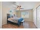 Cozy bedroom with a ceiling fan, blue-patterned bedding, and natural light from a window at 1405 Bugle Boy Dr, Henderson, NV 89014