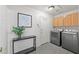 Laundry room with modern appliances, wooden cabinets, and stylish decor at 1405 Bugle Boy Dr, Henderson, NV 89014