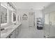 Clean bathroom featuring double sinks, frameless shower, and modern gray storage at 1405 Bugle Boy Dr, Henderson, NV 89014