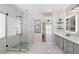 Bright bathroom with glass shower, marble floors, and modern gray vanity at 1405 Bugle Boy Dr, Henderson, NV 89014