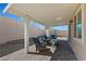 Covered patio with outdoor seating, grill, and view of the private backyard with brick pavers at 1405 Bugle Boy Dr, Henderson, NV 89014
