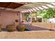 Relaxing backyard patio area with textured retaining walls, decorative pots, and a pergola at 14525 Heyer Way, Las Vegas, NV 89161