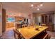 Bright kitchen and dining area with a large wooden table, an island, and plenty of storage space at 14525 Heyer Way, Las Vegas, NV 89161