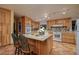 Charming kitchen with wood cabinets, an island, and tiled countertops and backsplash at 14525 Heyer Way, Las Vegas, NV 89161