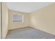 A bright bedroom with neutral walls and carpet and a window allowing for plenty of natural light at 15 Richland Acres Ct, Henderson, NV 89074