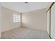 A bedroom with neutral walls and carpet with a view to the closet, and a window allowing for plenty of natural light at 15 Richland Acres Ct, Henderson, NV 89074