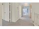 Well-lit hallway features plush carpeting, white walls, and entryways to the living spaces of the home at 15 Richland Acres Ct, Henderson, NV 89074